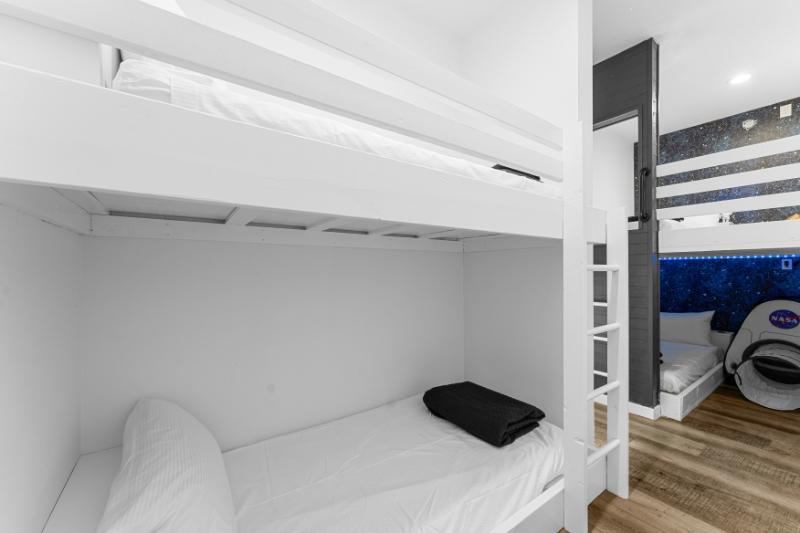 Shoot for the stars in this playful bunk room—NASA tent, twinkle lights, and fun for all.