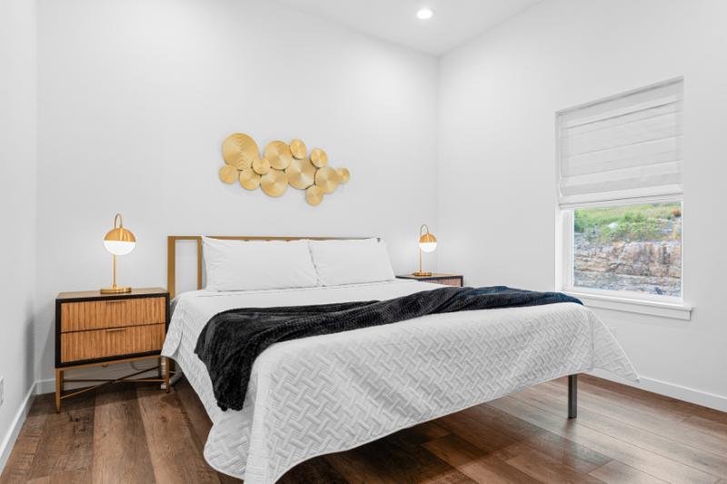 Drift off in this dreamy king bedroom with golden touches and peaceful views out the window.