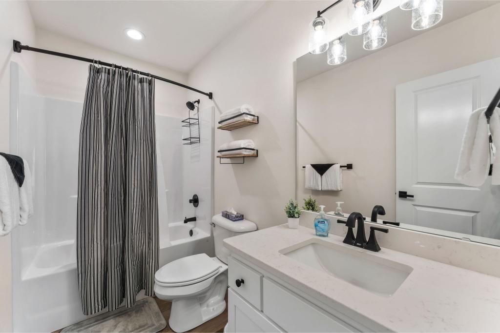 Whether you’re in the mood for a bubble bath or a quick rinse, this ensuite bath has you covered.