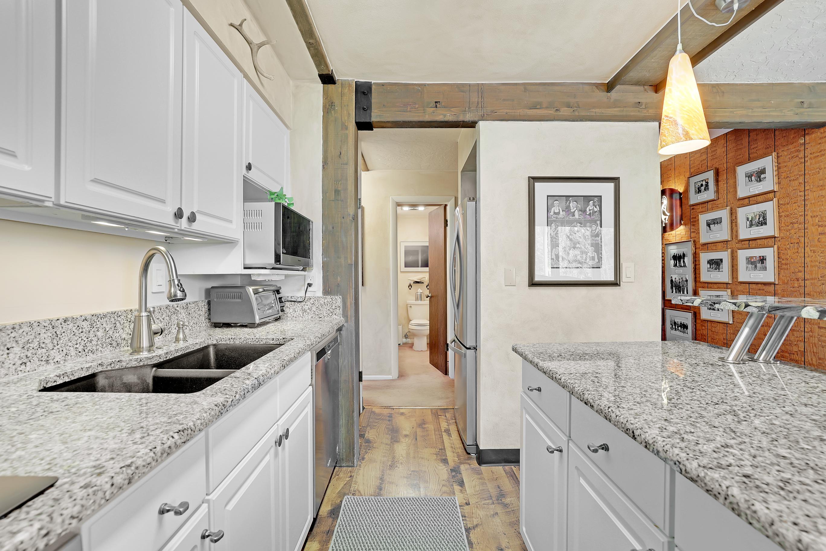 Galley kitchen with refrigerator, freezer, washer/dryer, and main floor bathroom