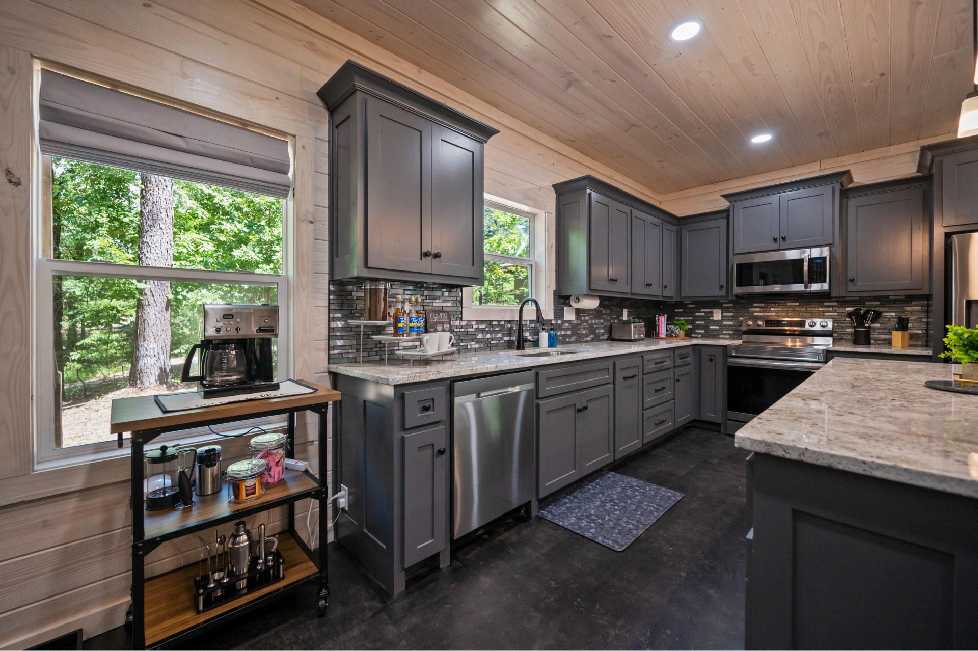 The kitchen features a fully stocked coffee bar with a drip maker, French press, frother, grinder, and starter supply of coffee, tea, and syrups—everything you need to fuel your stay.
