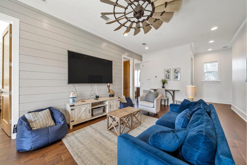 Second-floor den with large-screen Smart TV, office desk, and plenty of comfy seating—ideal for work, play, or movie nights.