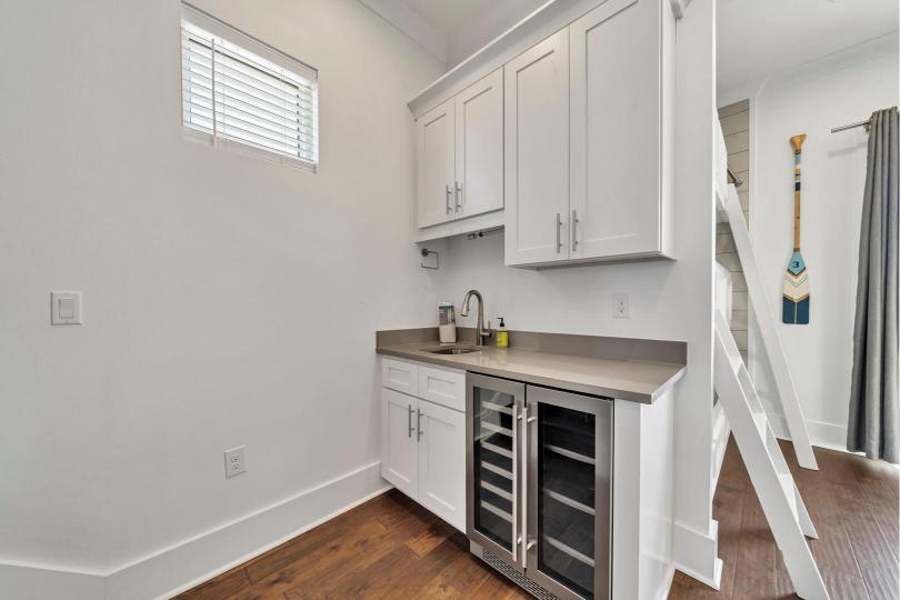 Second-floor wet bar just off the den, featuring a wine fridge and ample storage—perfect for evening drinks and easy entertaining.