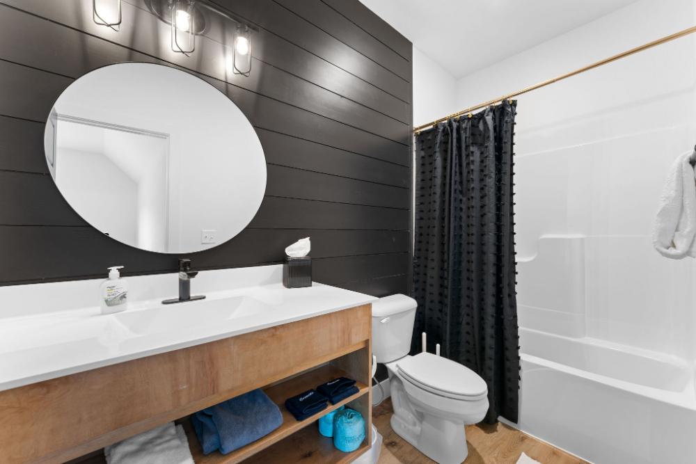 This sleek ensuite bath sits just off the trundle-friendly king suite—perfect for added convenience.