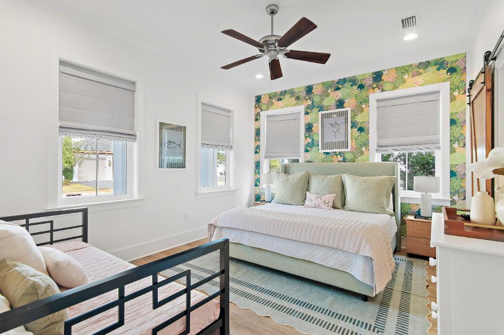 King bedroom with vivid feature wall, blackout shades, and natural light throughout.