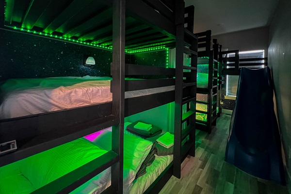 Kids will love this epic bunk room with 6 full-size beds, a slide, and even a space tent for out-of-this-world fun!