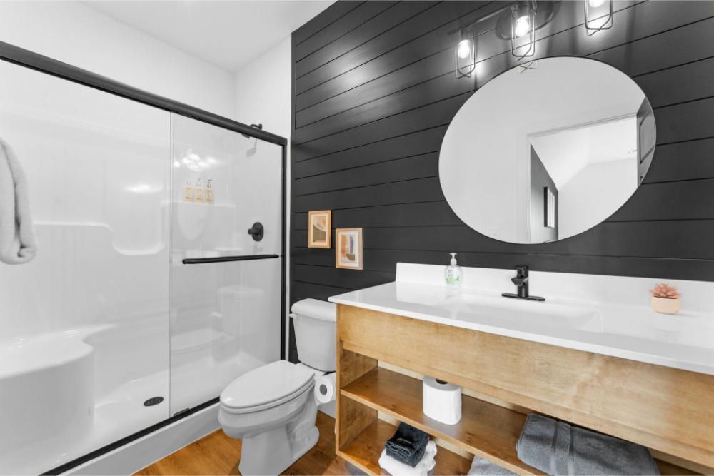 This private bathroom is fully stocked with towels, toiletries, and a modern glass shower.