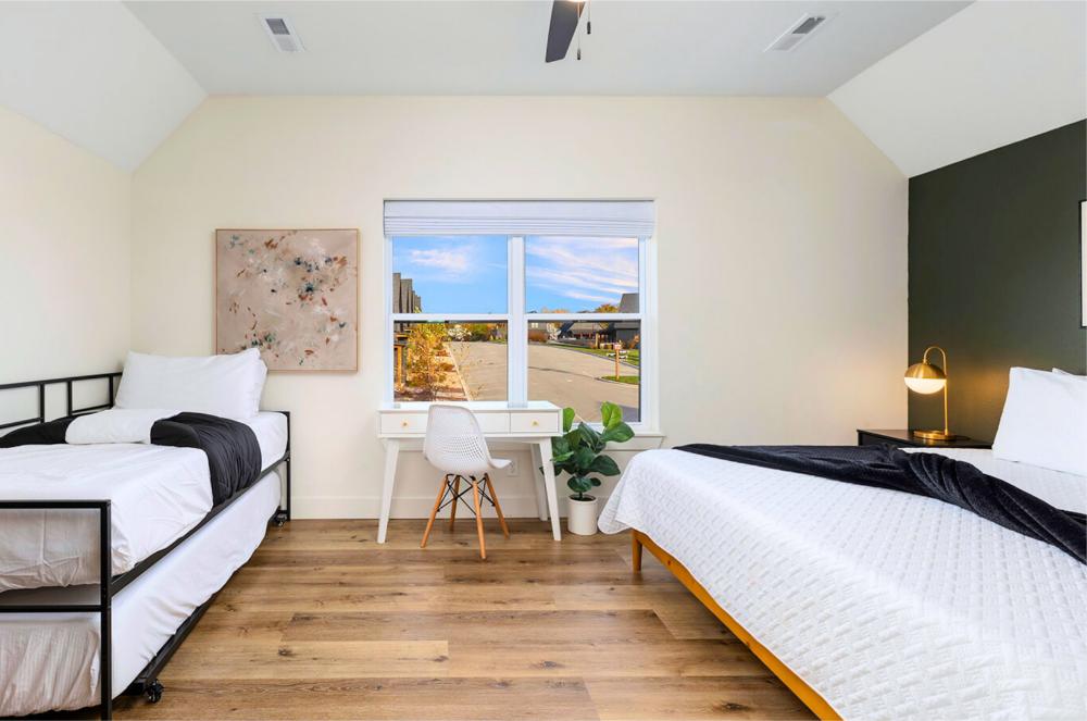 This upstairs bedroom includes a king bed, twin trundle, desk workspace, and views of the community pool.