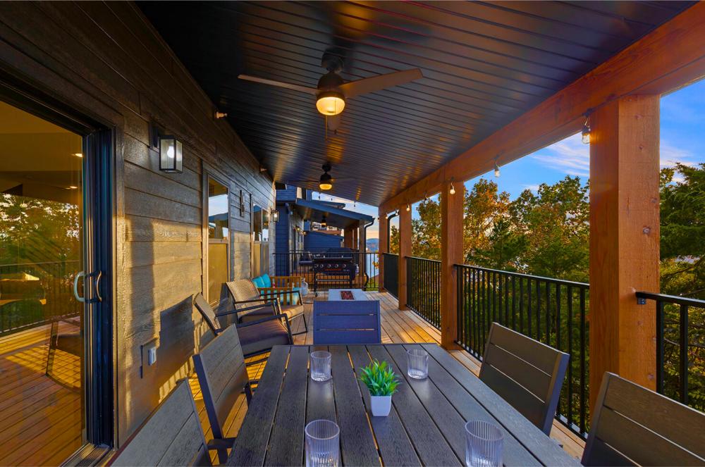 The main-level deck is fully equipped with a fire table, Blackstone griddle, and outdoor dining setup—perfect for alfresco meals and fireside hangs.