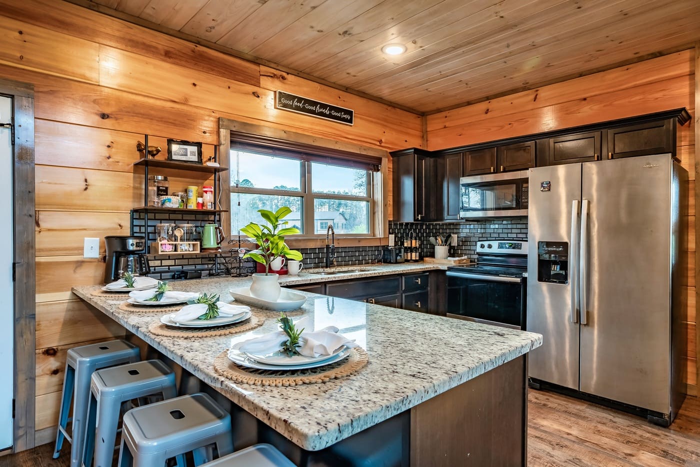Kitchen with island seating, stainless steel appliances, and coffee station.