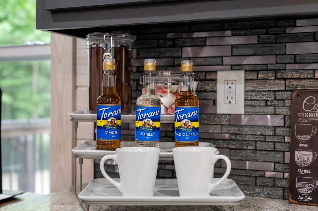 Coffee bar equipped with drip coffeemaker and a variety of beverage essentials.