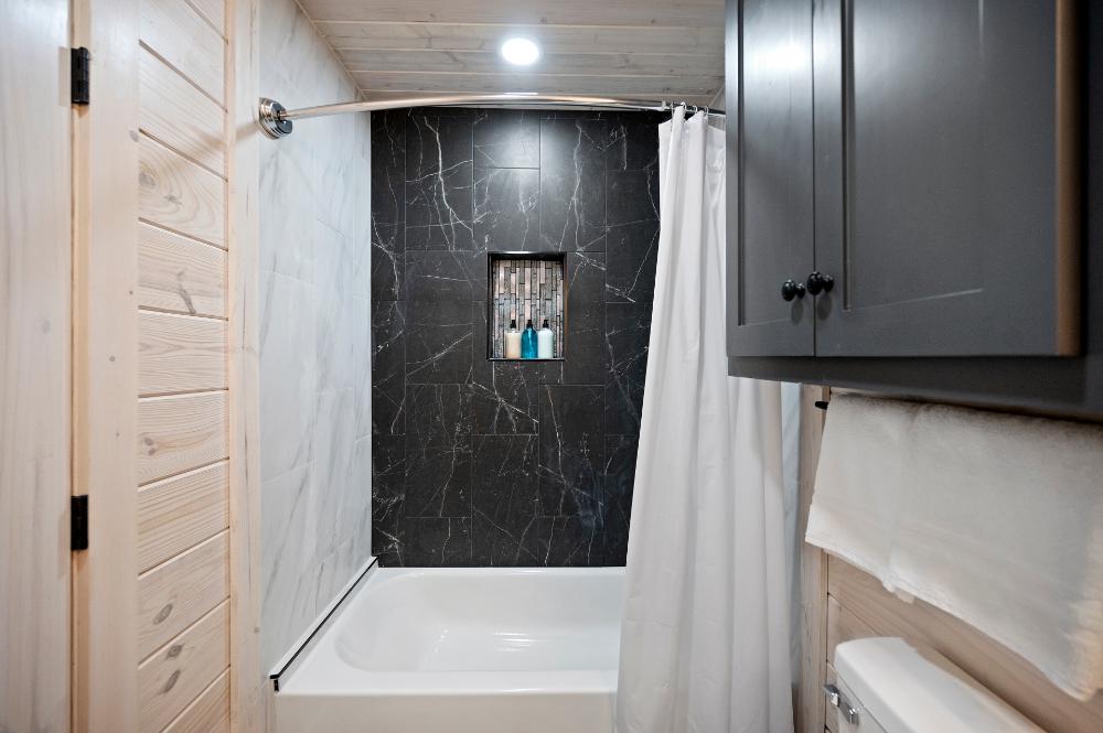 Bathroom featuring tub and tiled shower combination.