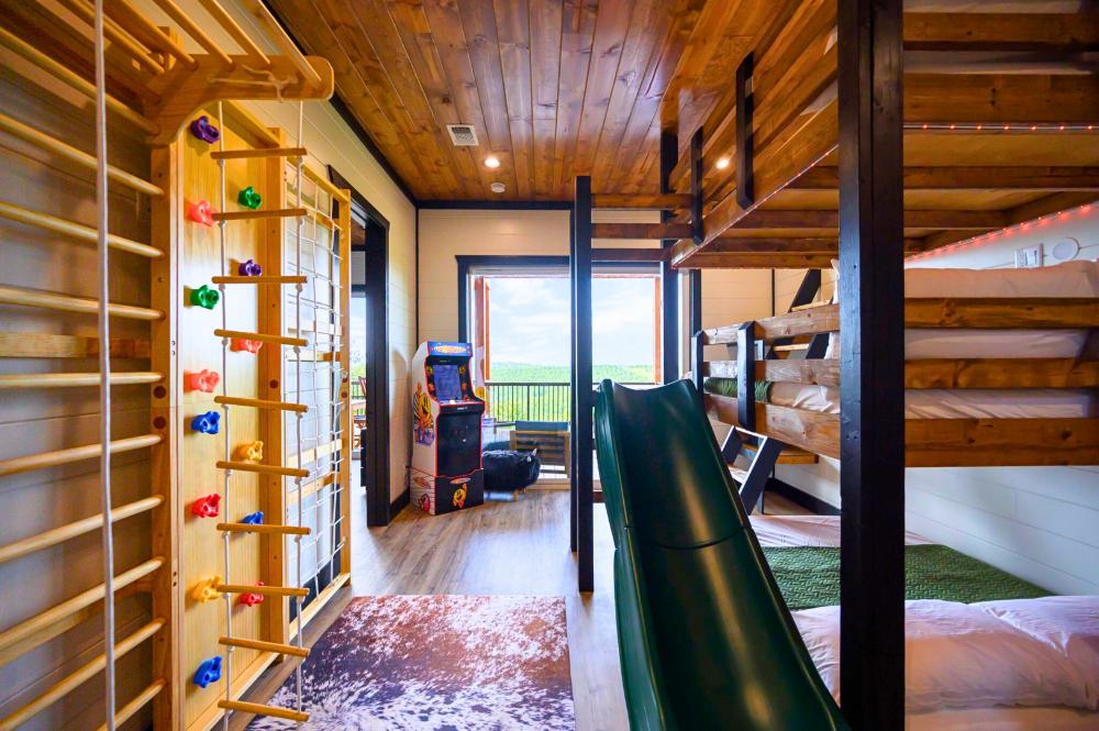 A bunk room with a slide, climbing features, and games built right in. Kids get their own world and parents get a little peace.