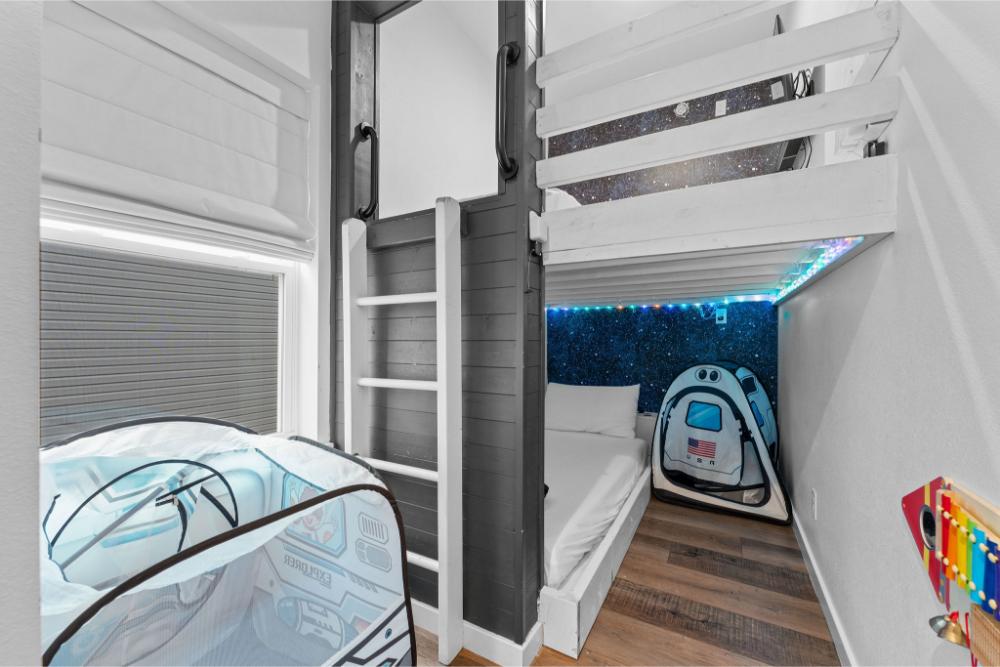 A fun filled kids’ retreat with two twin bunks, twinkling lights, and a lofted play area made for imagination.