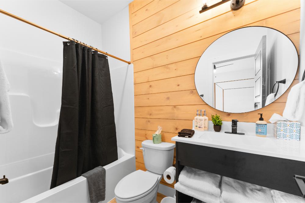 This full bathroom combines rustic details with modern finishes, including a tub and shower combination.