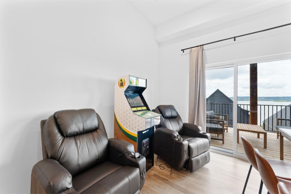 Entertainment area with golf simulator, arcade game, and massage seating.