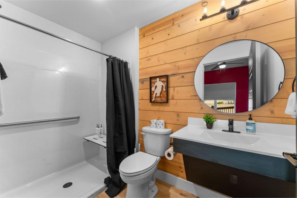 This main-level king suite features a plush bed and convenient access to a nearby bathroom.