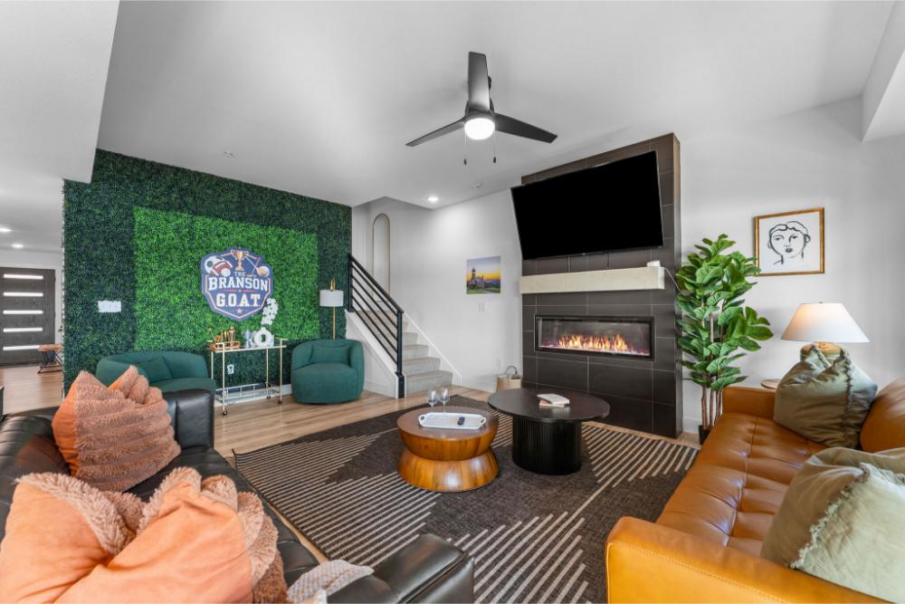 Relax in the living room with comfortable seating and a cozy electric fireplace as the focal point.