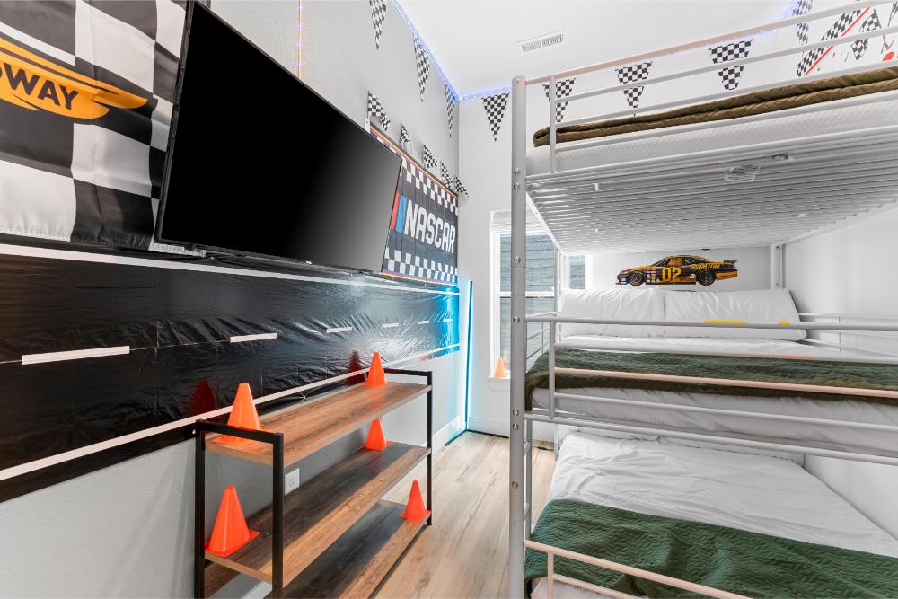 Racecar-themed bunk room features three full-size beds and playful design details for guests of all ages.
