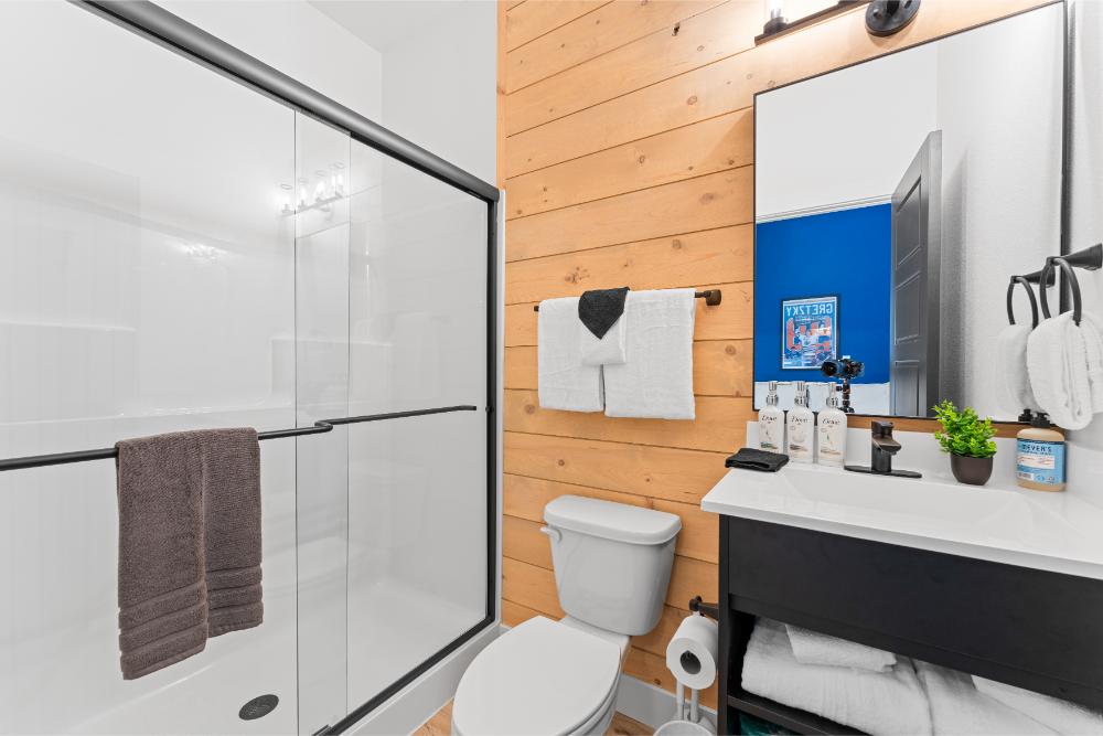 This private bathroom features hockey-themed accents and convenient amenities for a comfortable stay.