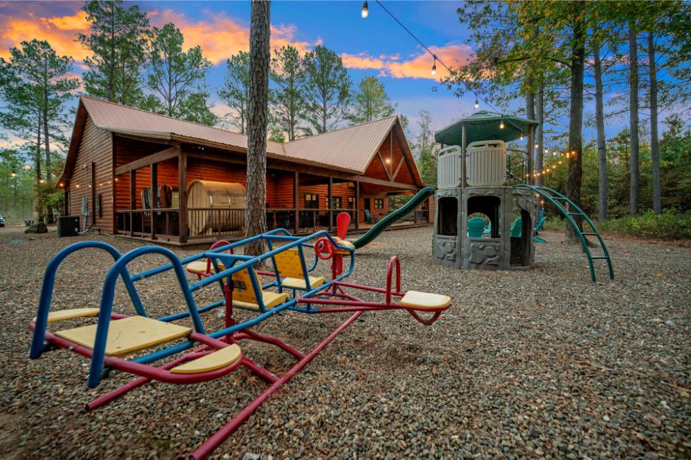 Enjoy the ultimate backyard retreat with a private sauna, hot tub, and play area, all set against a serene woodland backdrop.