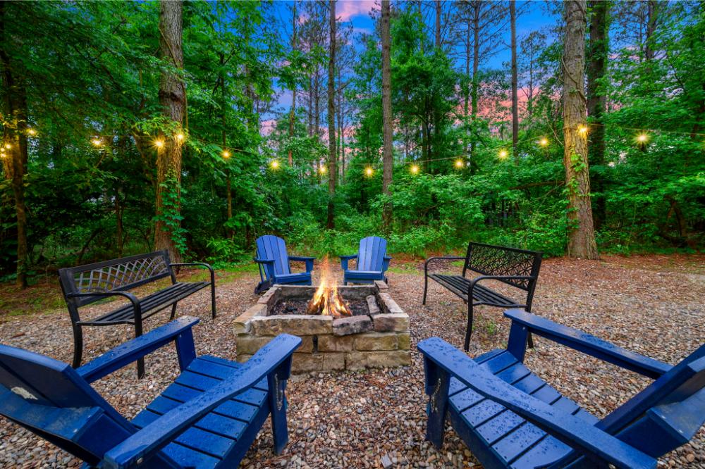 Backyard featuring fire pit, hot tub, Hypedome, playground, and outdoor dining area.