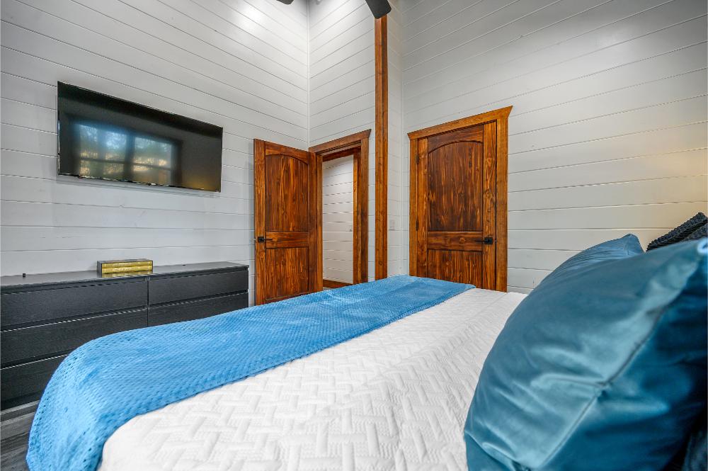 Relax in this upstairs king bedroom featuring a Smart TV, dresser, and closet for convenience.