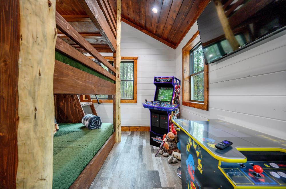 A fun bunk room with three beds, arcade games, and a Smart TV, perfect for kids and teens.