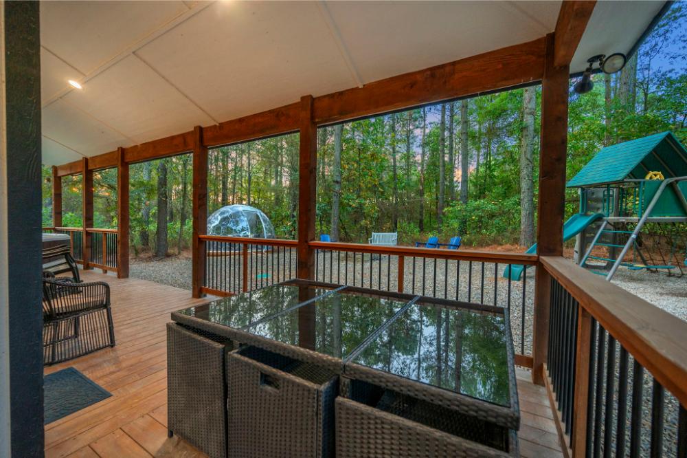 The backyard features a covered deck, outdoor dining, playground, fire pit, and Hypedome for a complete outdoor setup.